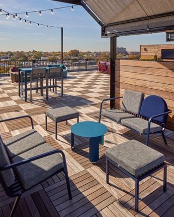 A patio with chairs and tables is set up on a wooden deck.